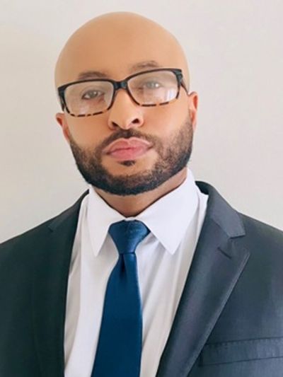 Professional man in glasses wearing a suit and blue tie.