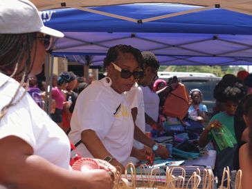 People gathered under a tent at a daytime event.