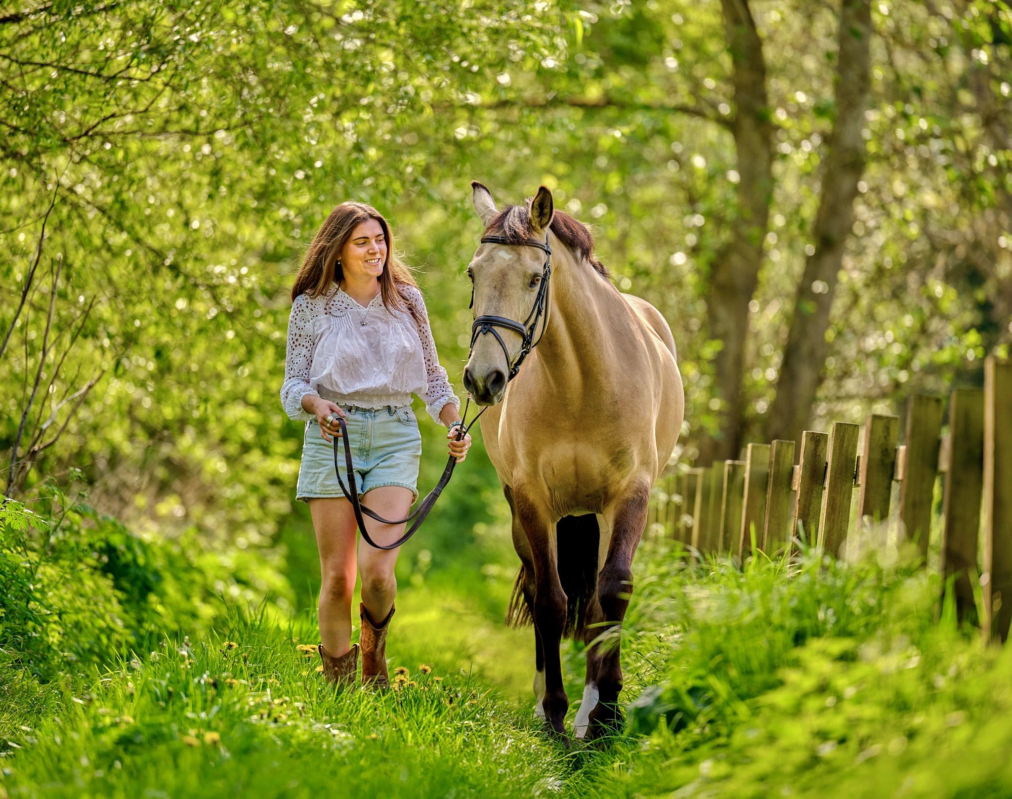 Beautiful light, diffused through the summer trees, perfectly illuminates a young girl and her horse