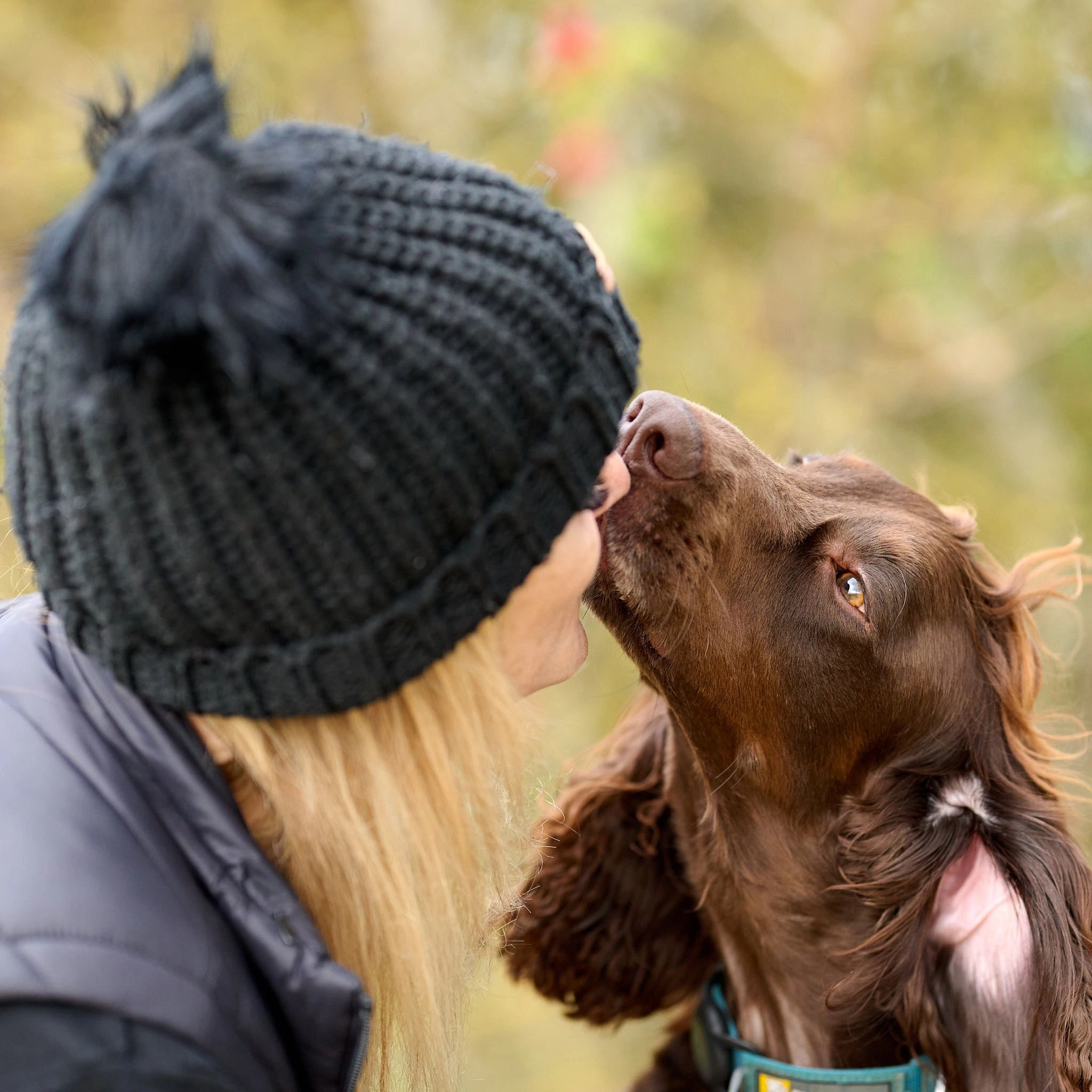 A photograph of a young lady kissing her brown Cocker Spaniel dog in Oxfordshire UK