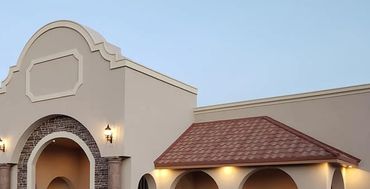 Elegant building facade with arches and warm lighting at dusk.