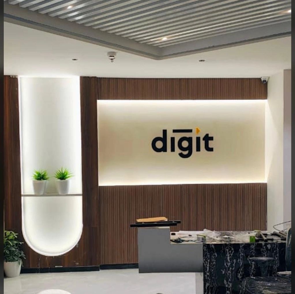 Modern office reception area with illuminated 'digit' logo and sleek decor.