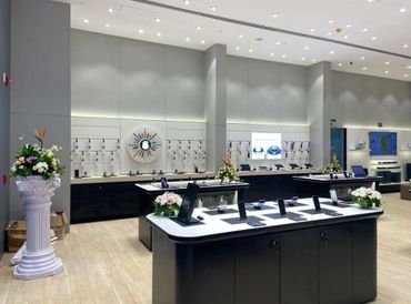 Modern electronics store with sleek displays and floral decor.