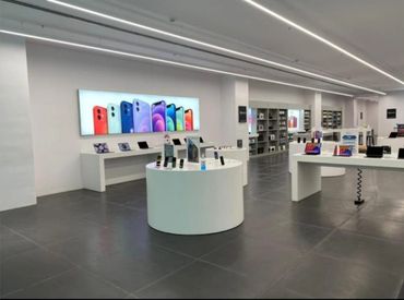 Modern tech store with sleek white displays showcasing smartphones and tablets.