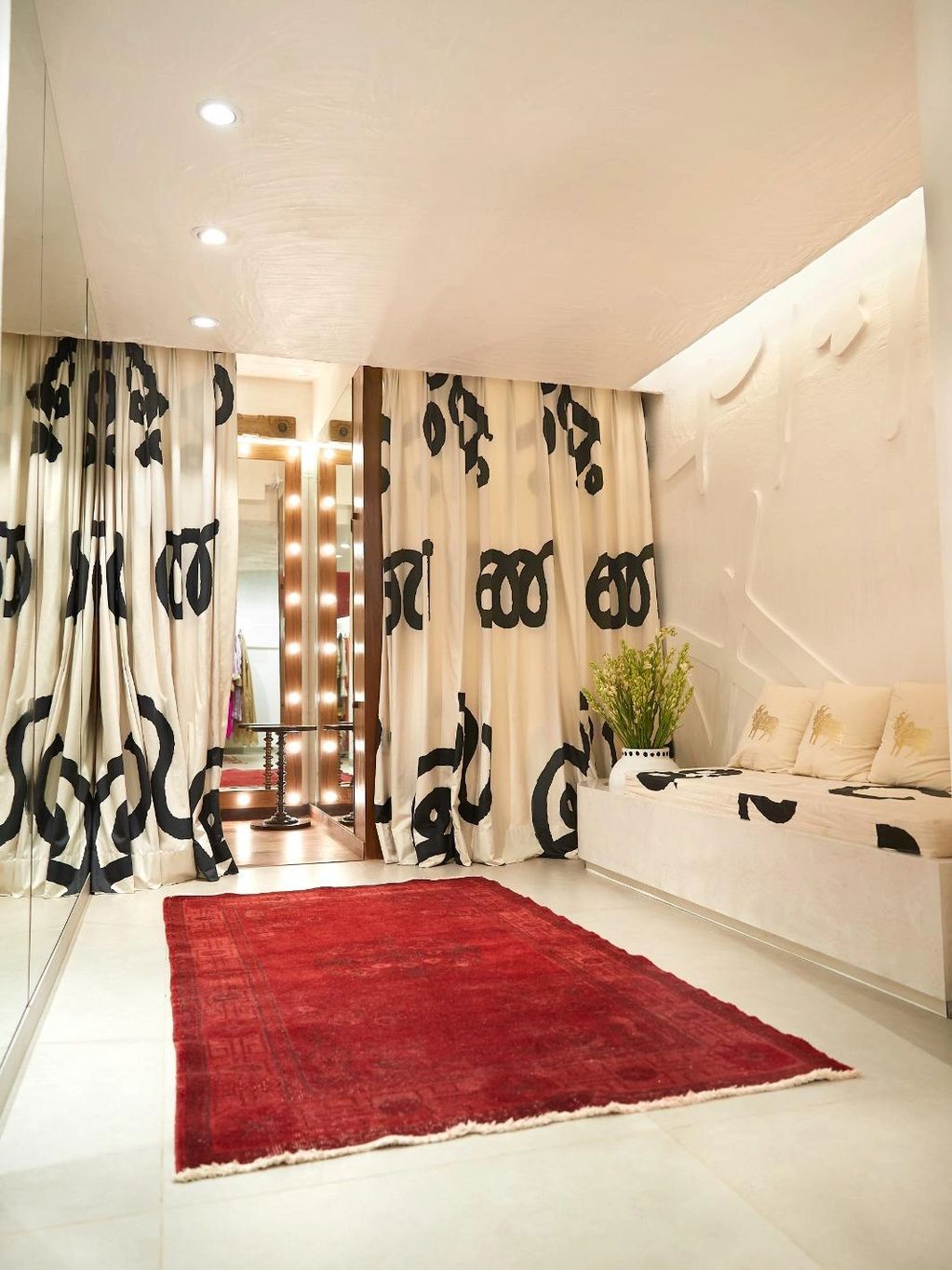 Minimalist dressing room with red rug and patterned curtains.