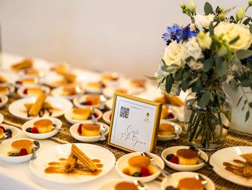 A table beautifully set with desserts and a floral centerpiece.