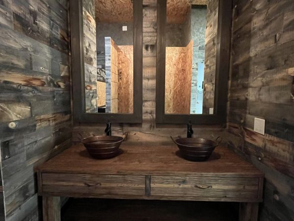 Rustic bathroom with wooden vanity and dual sinks.