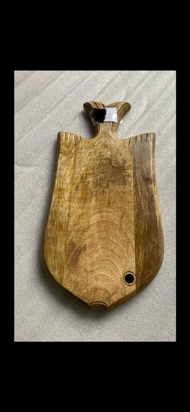 Handcrafted wooden chopping board with a unique carved handle.