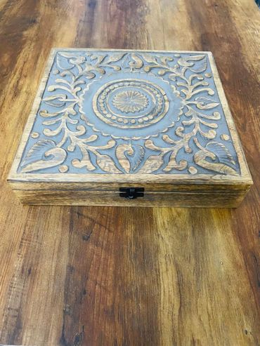 Ornate wooden box with intricate carved floral patterns on its lid.