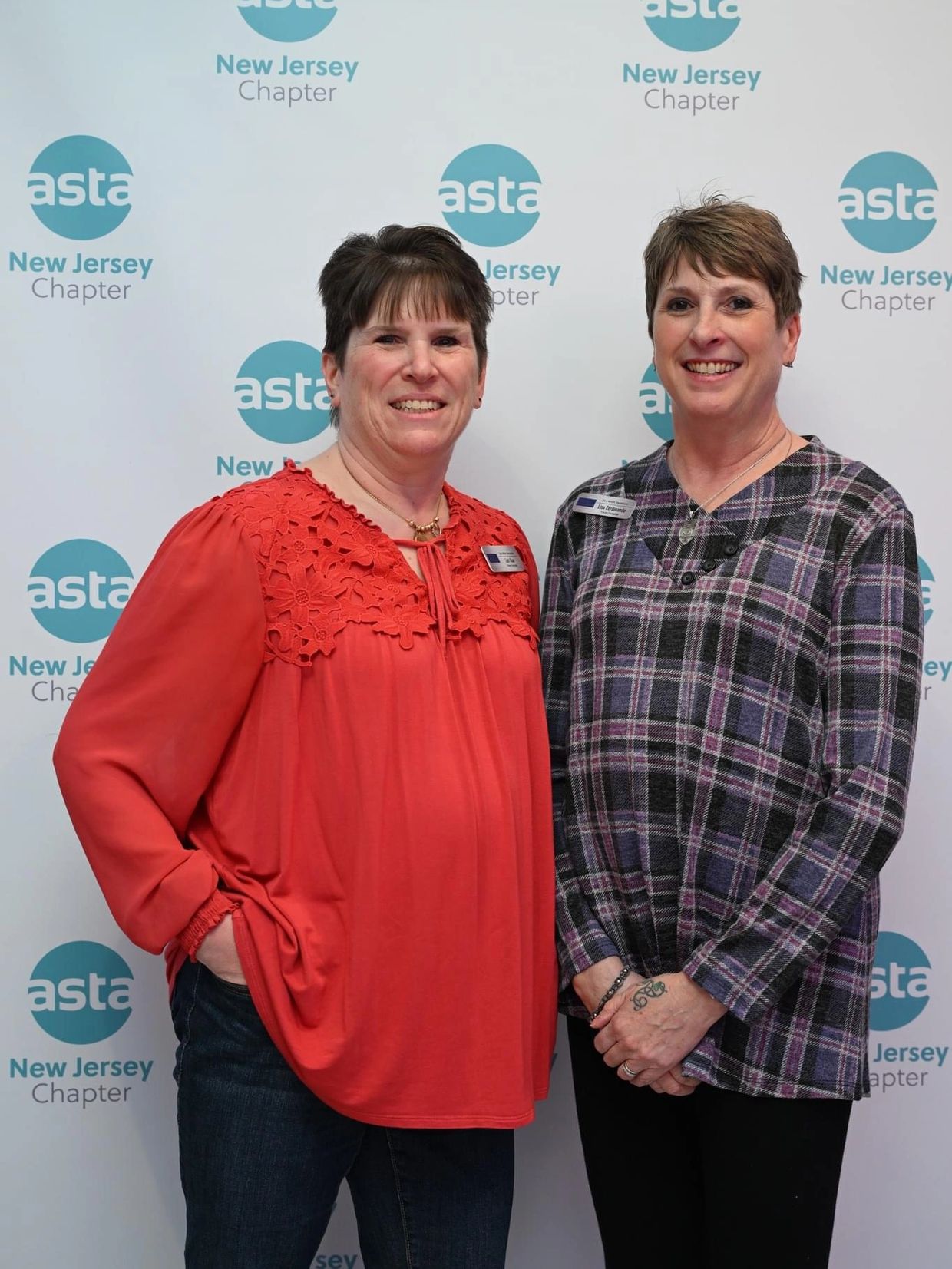 Two women smiling at an Asta New Jersey Chapter event.