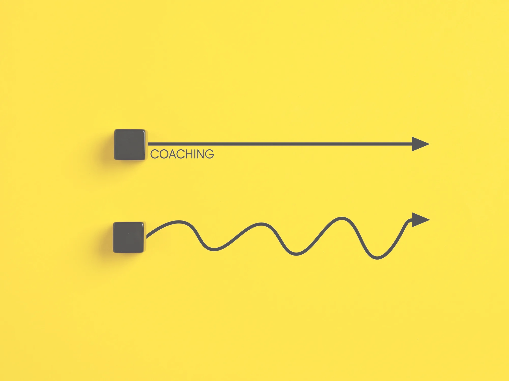 Two black cubes with arrows on a yellow background illustrating coaching progress.