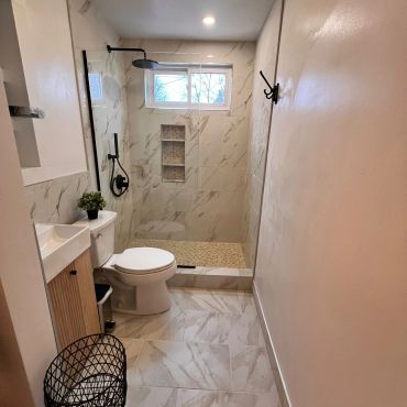Modern bathroom with marble tiles, walk-in shower, and minimalist fixtures.