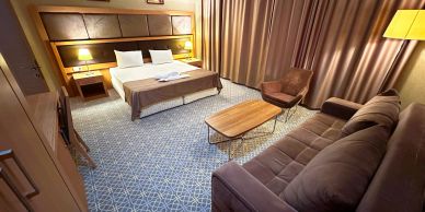 Cozy hotel room with bed and seating area.