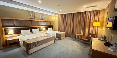 Modern hotel room with a double bed and a single bed.