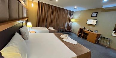 Hotel room with two beds and a desk.