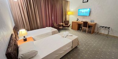Hotel room with two single beds and a TV.