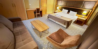 Spacious hotel room with a large bed and seating area.