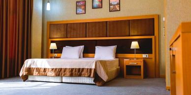 Modern hotel room with a double bed and bedside lamps.