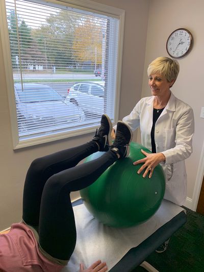 Dr. Greet treating a patient using an exercise ball

