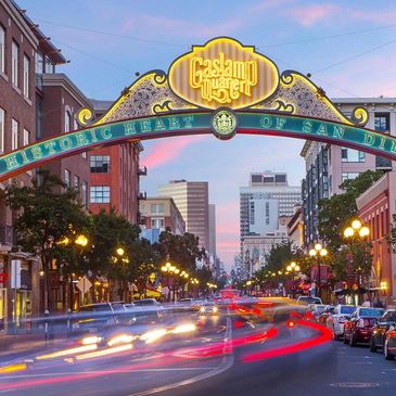 Twilight view of the bustling Gaslamp Quarter in Downtown San Diego, with its iconic archway sign and lively street scene capturing the essence of the city's historic heart.





