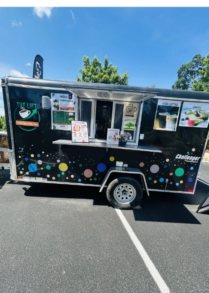 Black food truck with colorful polka dots and coffee logo.