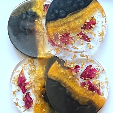 Black and gold coasters made with resin, containing rose petals and gold leaf