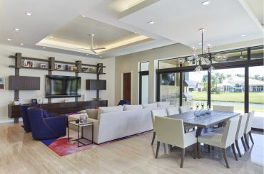 Modern living and dining room with large windows.