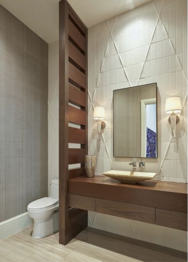Modern bathroom with wooden vanity and geometric wall design.