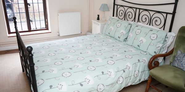 Cozy bedroom with a decorative iron bedframe and floral bedding.