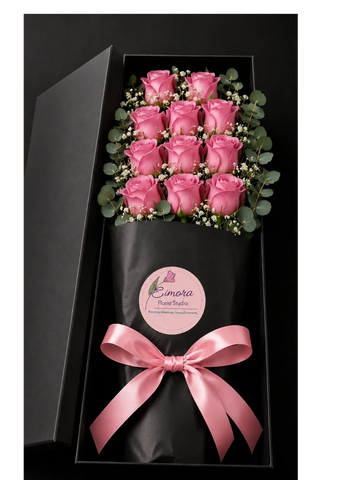 Elegant bouquet of pink roses in a black gift box with a pink ribbon.