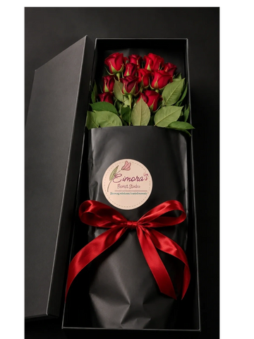 Elegant bouquet of red roses in a black gift box with a red ribbon.