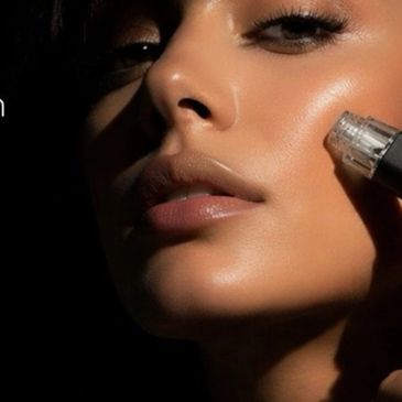 Close-up of a woman using a skincare device on her cheek.