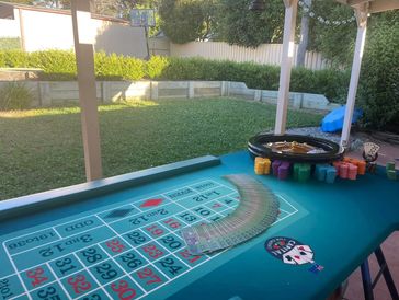Outdoor casino poker table with cards and chips.