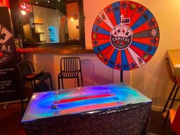 Colorful spin wheel and illuminated betting table in a casino.
