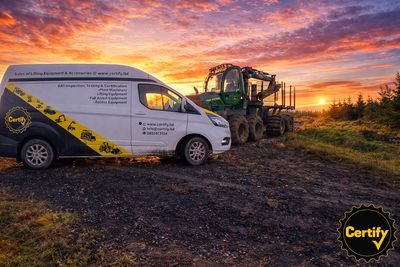 A Certify van and forestry machinery at sunset on a rugged terrain.