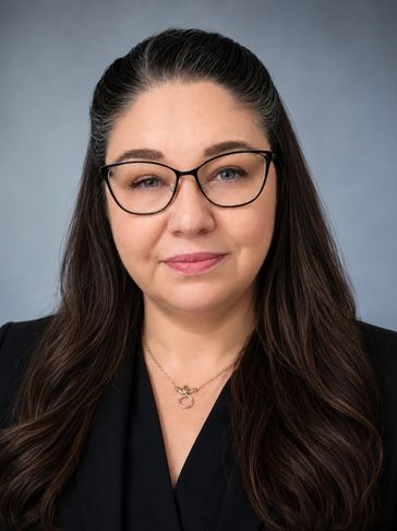 Professional woman with glasses and long dark hair.