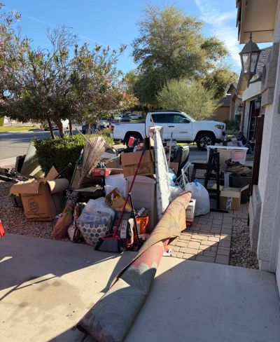 Pile of household items and clutter outside a house.