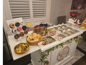 A dessert buffet with donuts, pastries, and sweets on a decorated table.