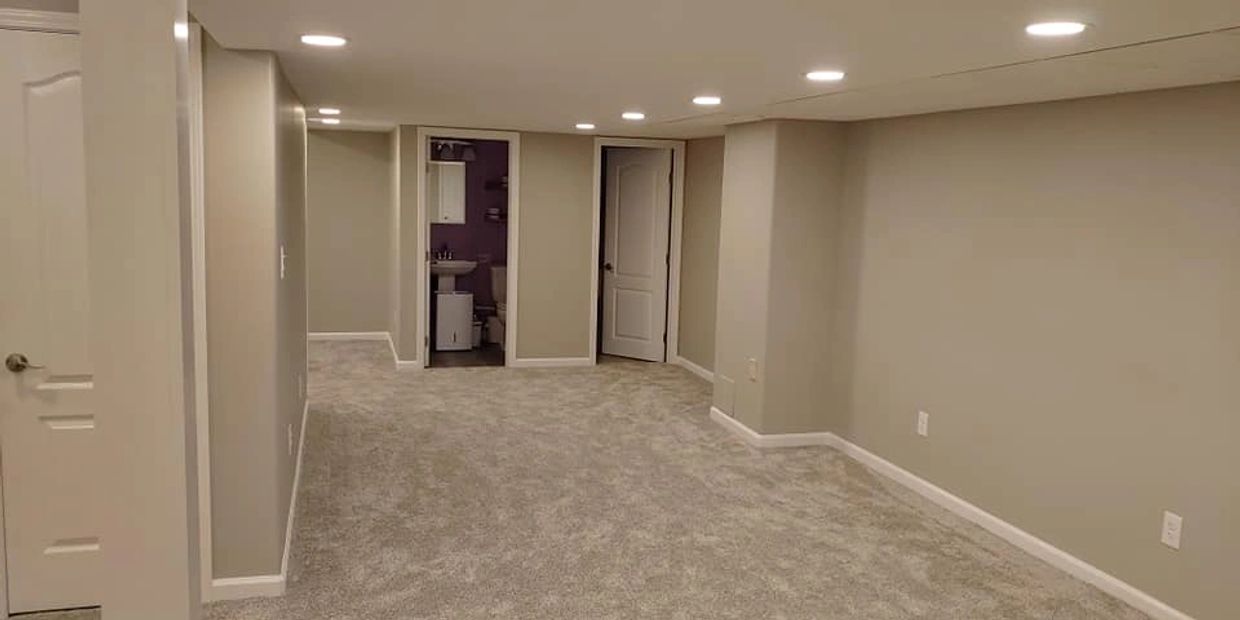 Finished basement remodel in Sterling, NY, by Rexyco LLC, featuring recessed lighting and carpet.