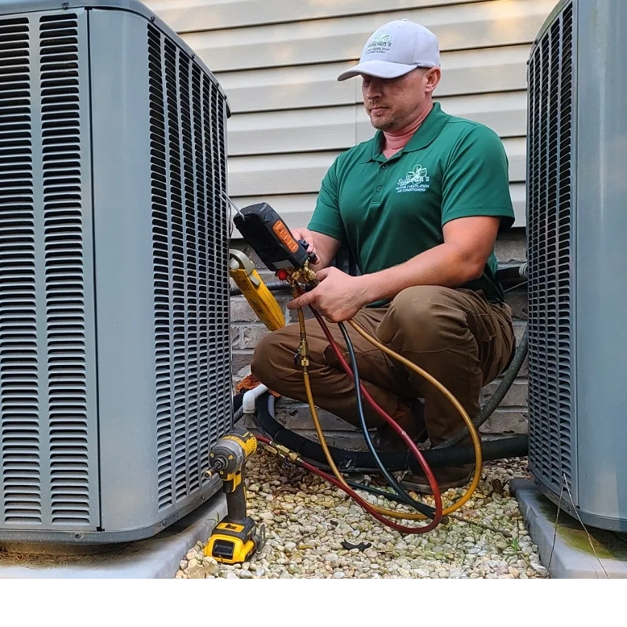 Sullivan's Heating and Air owner, Joe Sullivan, checks refrigerant pressures on aging Amana system.