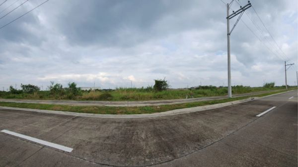 Empty rural road intersection with cloudy sky.