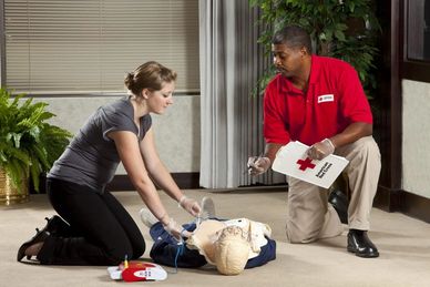Two people practicing CPR on a training mannequin.