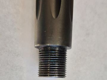 Close-up of a threaded metal cylindrical object with a black finish.