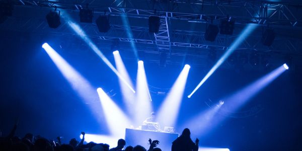 Close-up of a knob on a sound mixing console with blue lighting.