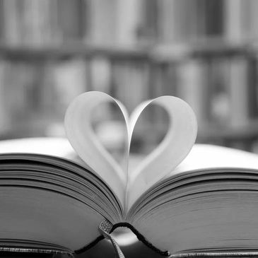 An open book with the pages turned inwards to create a heart