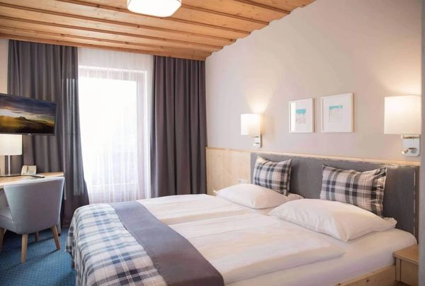 Cozy modern bedroom with plaid bedding and soft lighting.