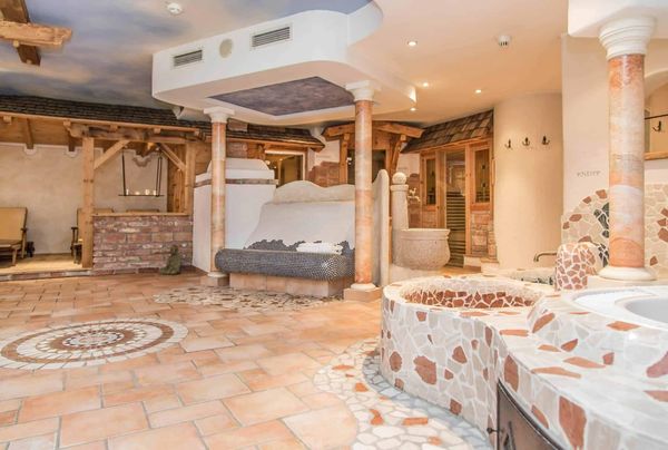 Luxurious spa area with mosaic-tiled jacuzzi and wooden accents.