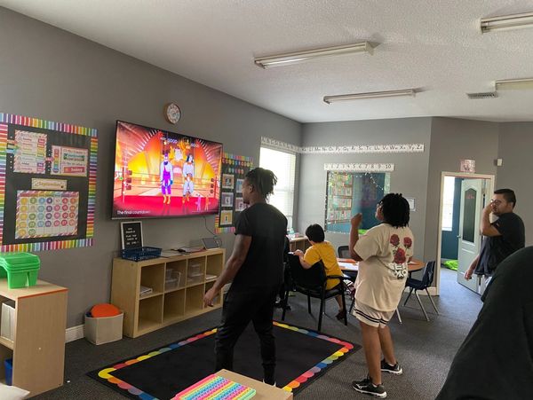 Students in a classroom playing an interactive game on a large screen.