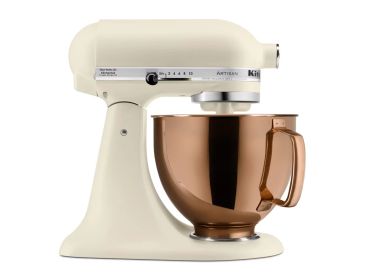 Cream KitchenAid stand mixer with copper bowl.