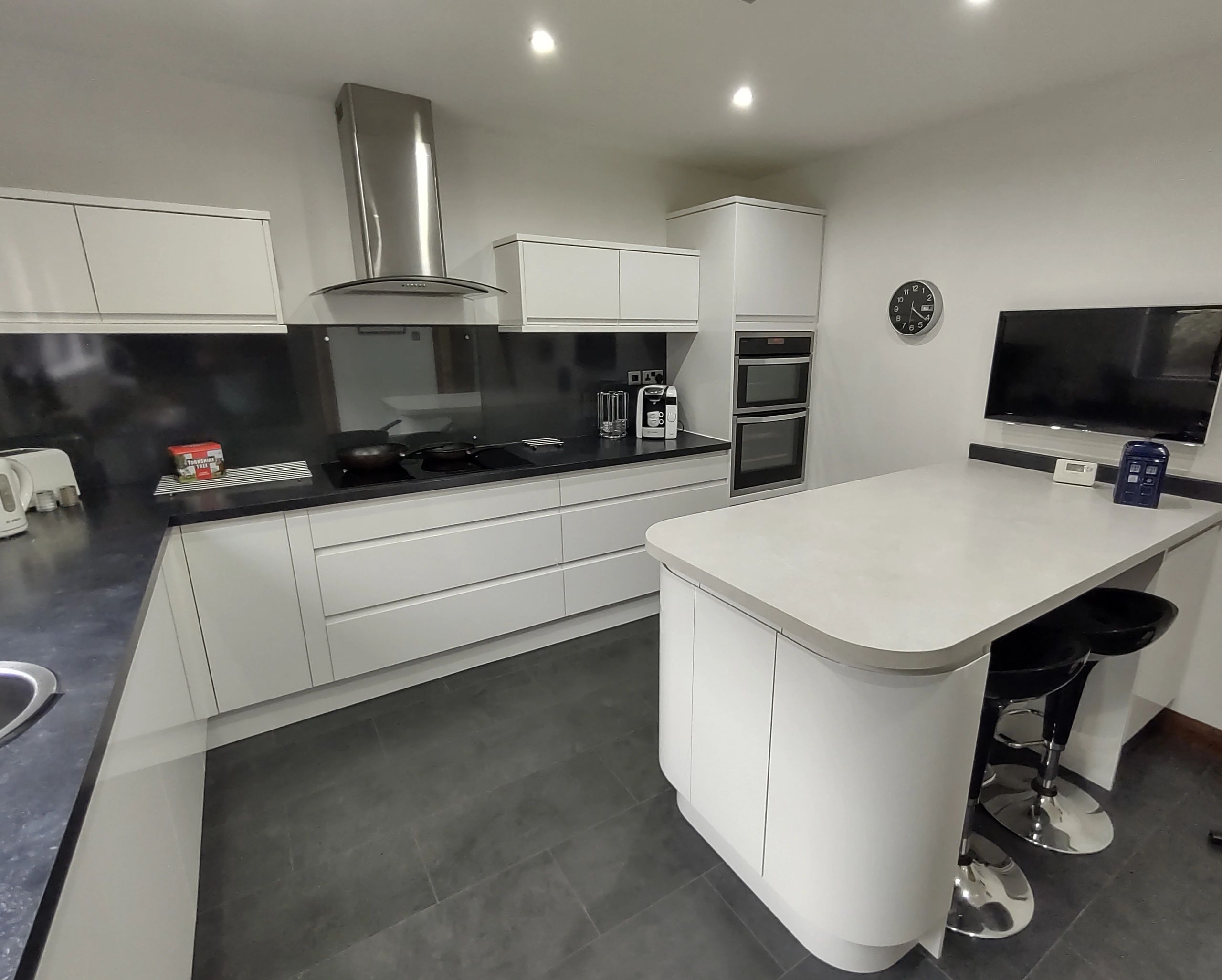 Modern white kitchen with island and appliances.